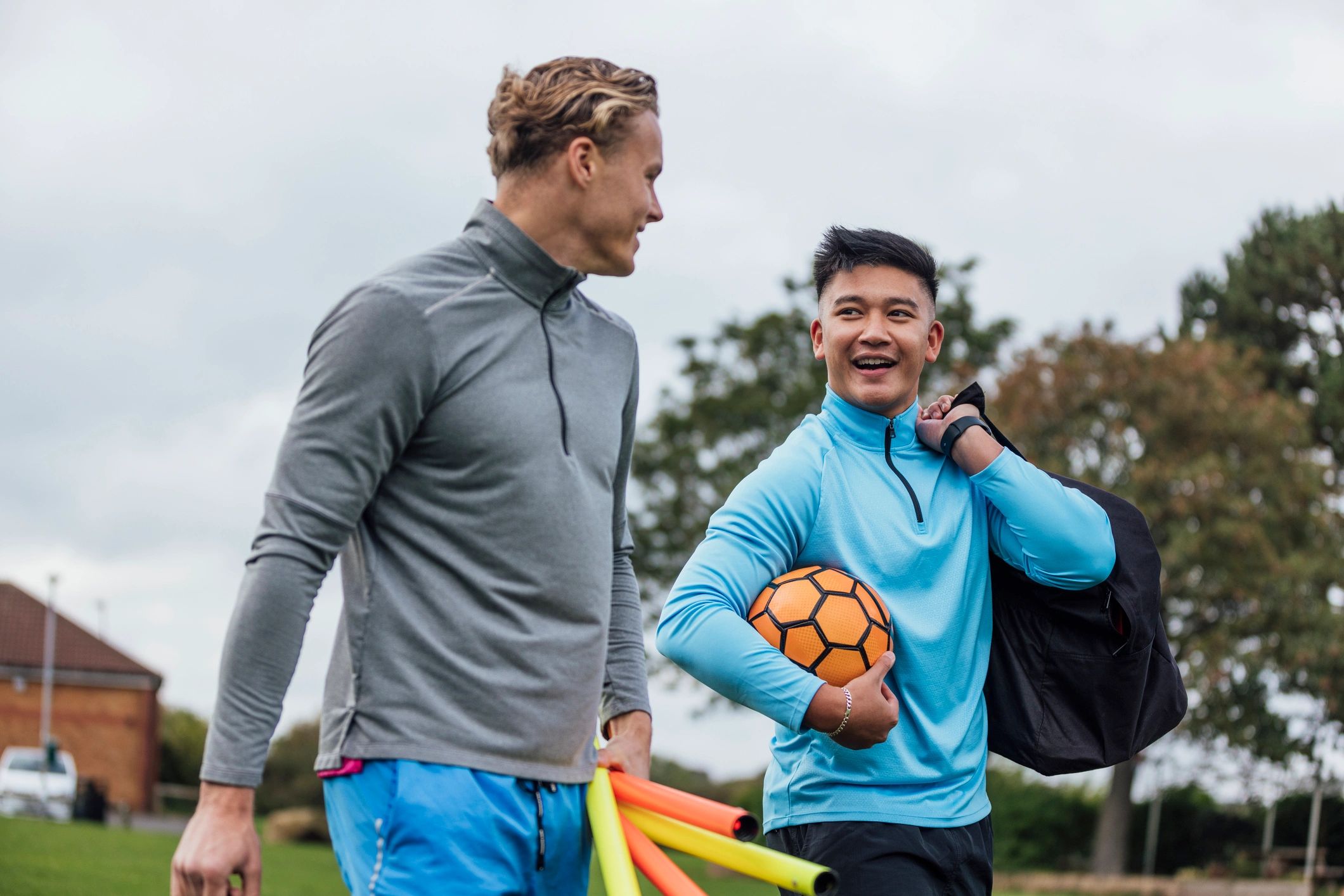Coaches and trainers walking together on a sports field