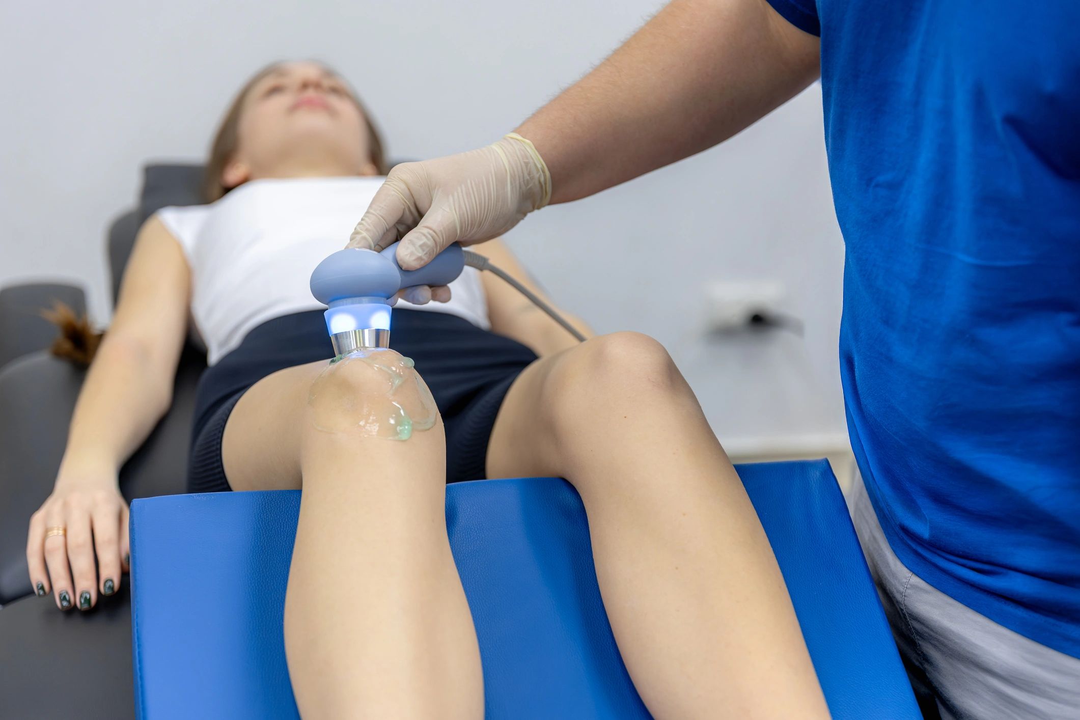 Doctor assessing a patient's shoulder during a rehab consultation